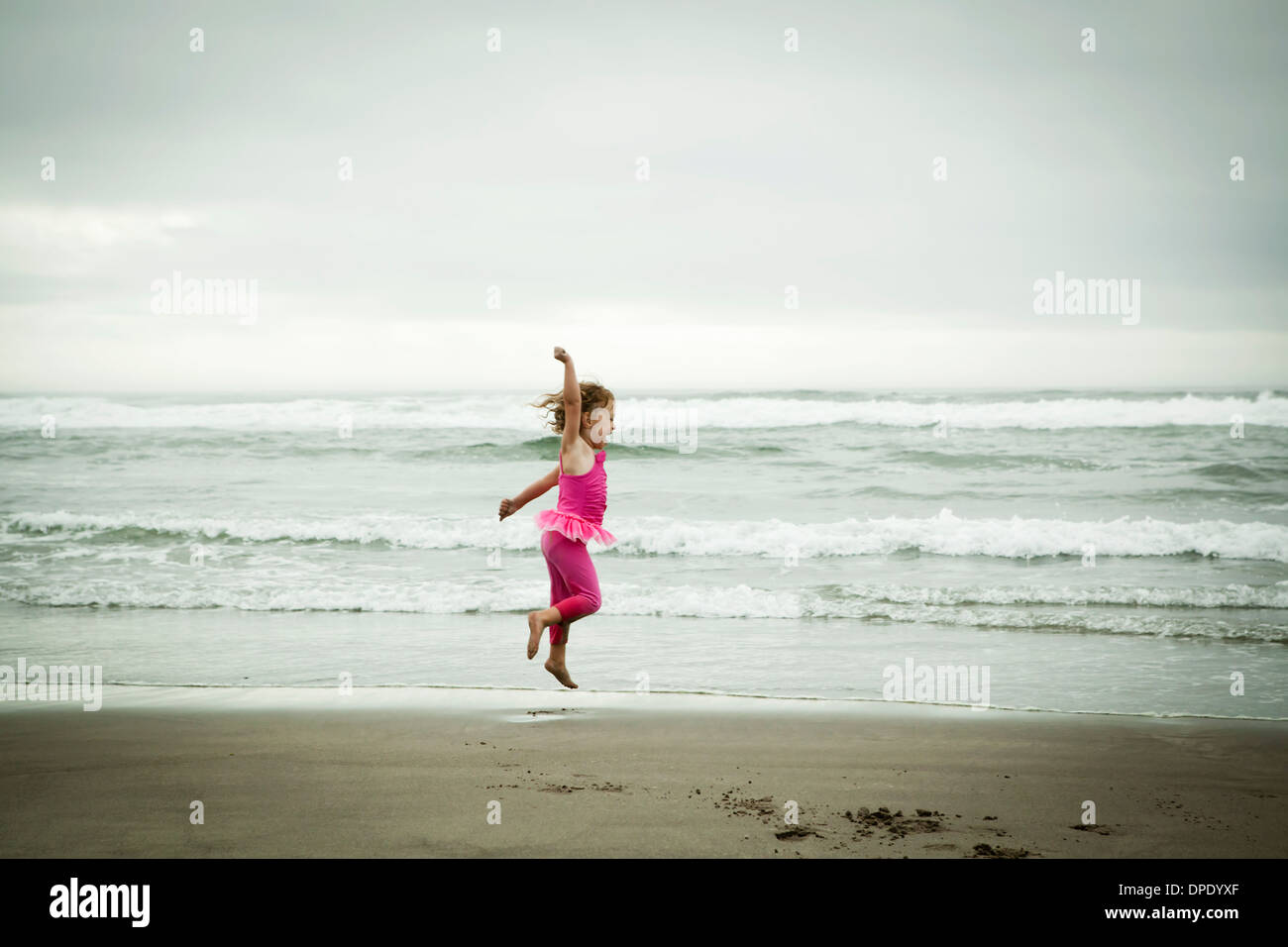 Toddler femmina salto sulla spiaggia Foto Stock