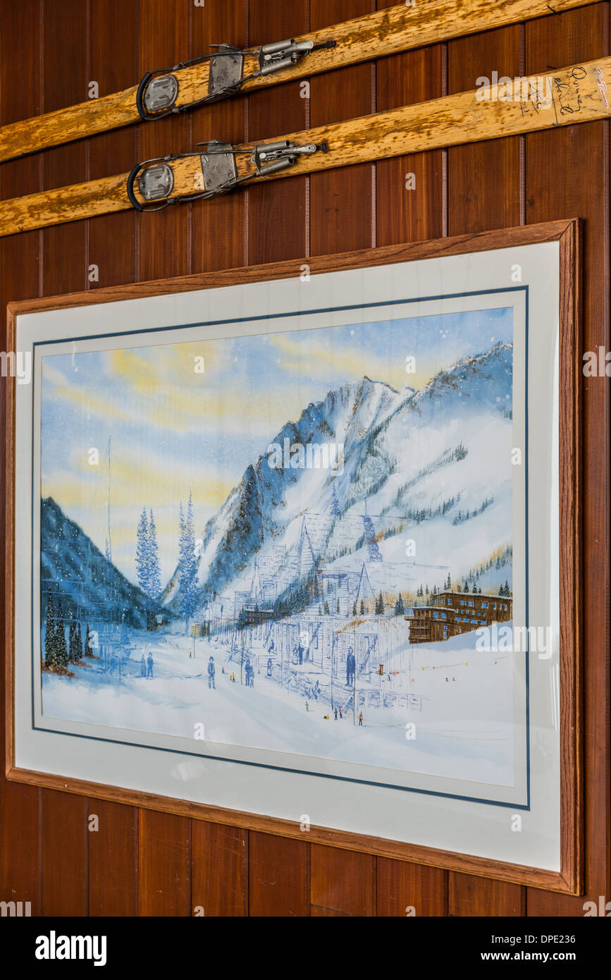 Un dipinto e coppia di vecchi sci decorare pareti in legno. Utah, Stati Uniti d'America. Foto Stock
