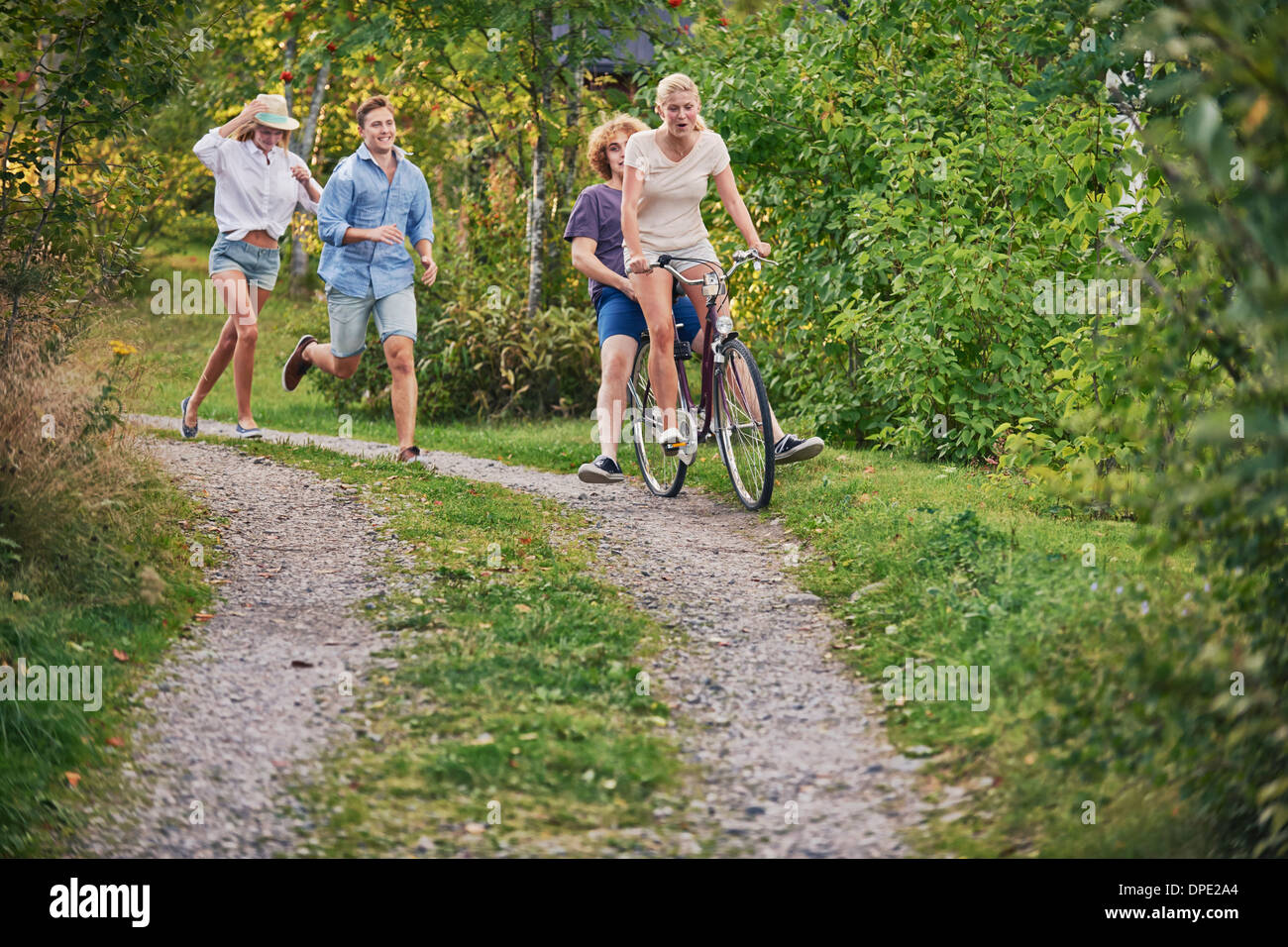 Due giovani coppie che si rincorrono lungo la pista sterrata, Gavle, Svezia Foto Stock