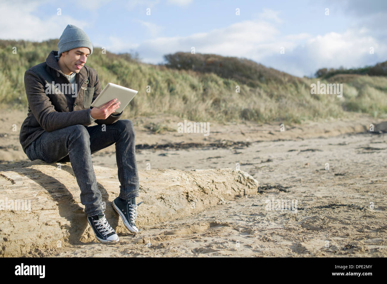 Giovane uomo con tavoletta digitale, Brean Sands, Somerset, Inghilterra Foto Stock
