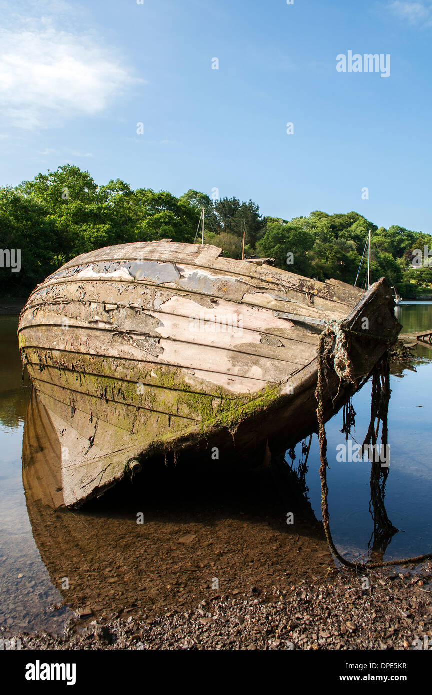 Una vecchia imbarcazione abbandonati e lasciati a marcire sul fiume helford in cornwall, Regno Unito Foto Stock