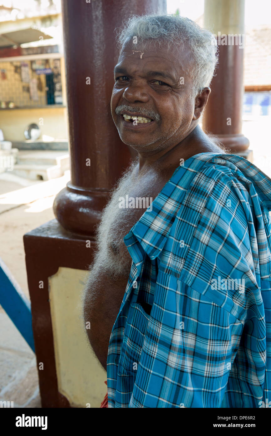 Tempio sorridente lavoratore con un bianco torace peloso nel cortile del l'Ettumanoor Mahadeva tempio, Ettumanoor, nei pressi di Kottayam Kerala, India Foto Stock