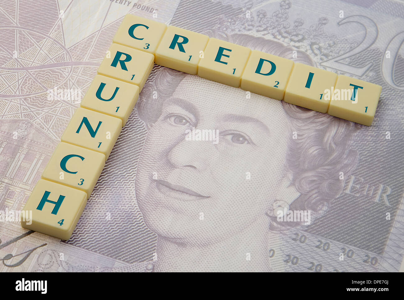 Credit Crunch scritto sulle tessere Scrabble e sovrapposto a una nota di sterlina da 20 sterline Foto Stock