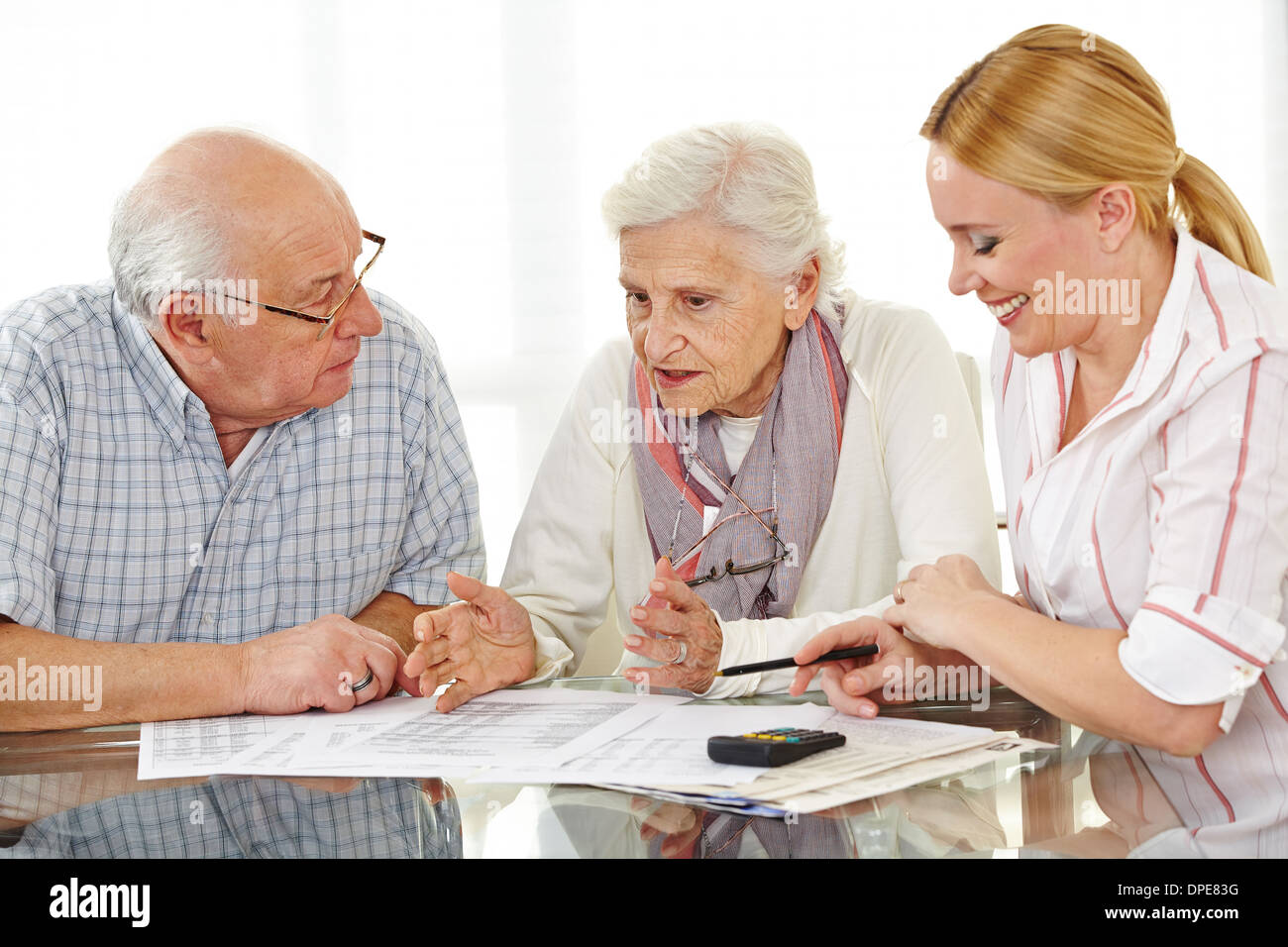 I cittadini anziani giovane argomentando nel corso di un contratto con il consulente finanziario Foto Stock