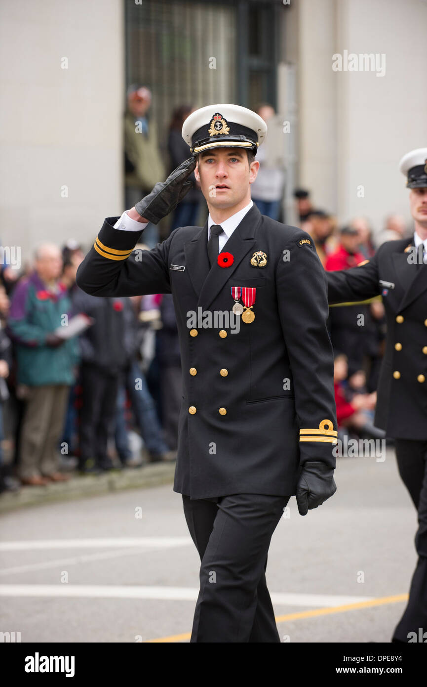 Canadian Naval Officer salutando mentre Marcia in ricordo di Vancouver Day Memorial corteo cerimoniale. Foto Stock