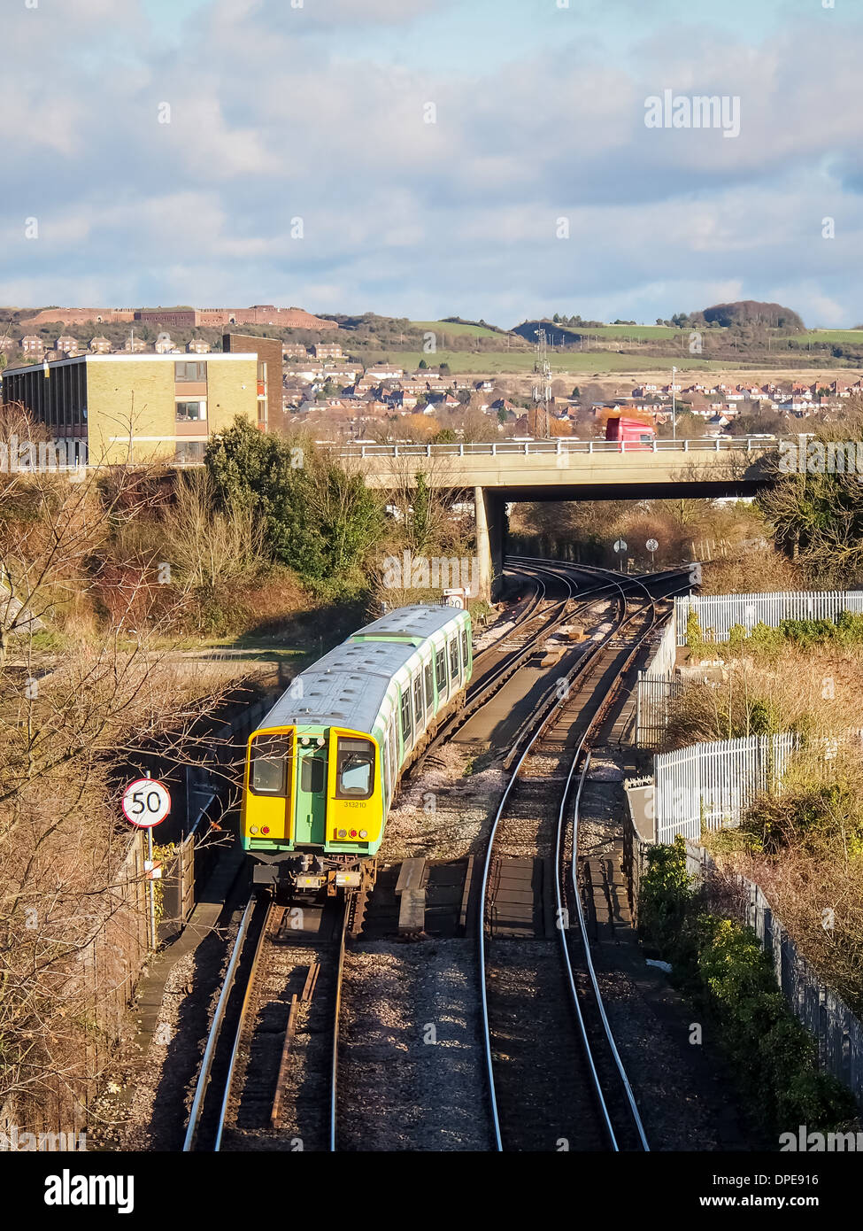 Il treno di classe 313 gestito dalle Ferrovie meridionali attraversa Portsbridge Creek ed entra nell'isola di Portsea, Portsmouth, Inghilterra Foto Stock