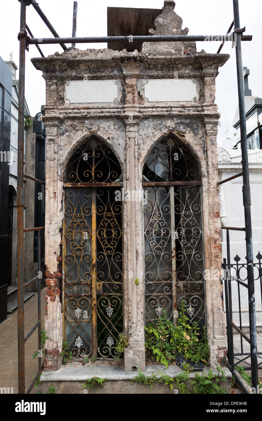 Recoleta Cemetery Mausoleum deteriorare Buenos Aires Argentina // BUENOS AIRES, Argentina — impalcature circondano un mausoleo in deterioramento nel Cimitero di Recoleta (Cementerio de la Recoleta), indicando gli sforzi di conservazione in corso. La struttura ornata ma fatiscente esemplifica le sfide del mantenimento dell'architettura funeraria storica. Foto Stock