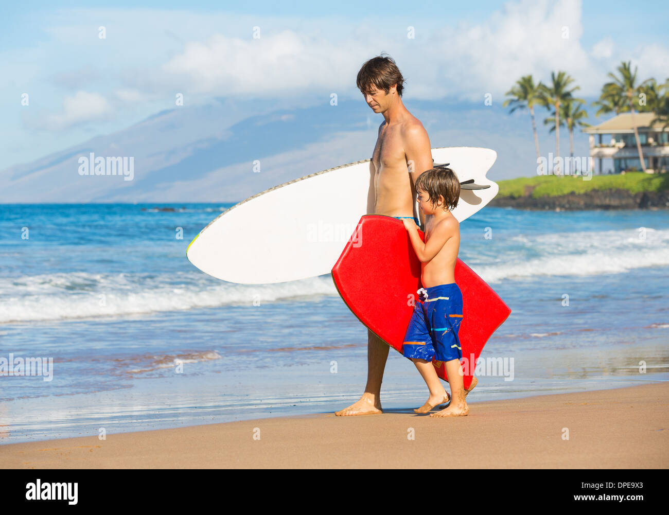 Padre e Figlio andando surfare insieme sulla spiaggia tropicale in Hawaii Foto Stock