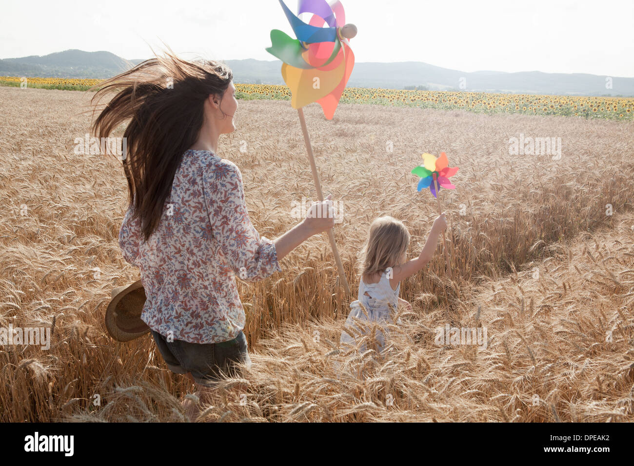 Madre e figlia in esecuzione attraverso il campo di grano Foto Stock