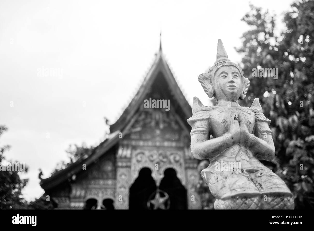 Una statua di Buddha in preghiera di fronte ad un edificio sul Palazzo Reale motivazione a Luang Prabang, Laos. Foto Stock