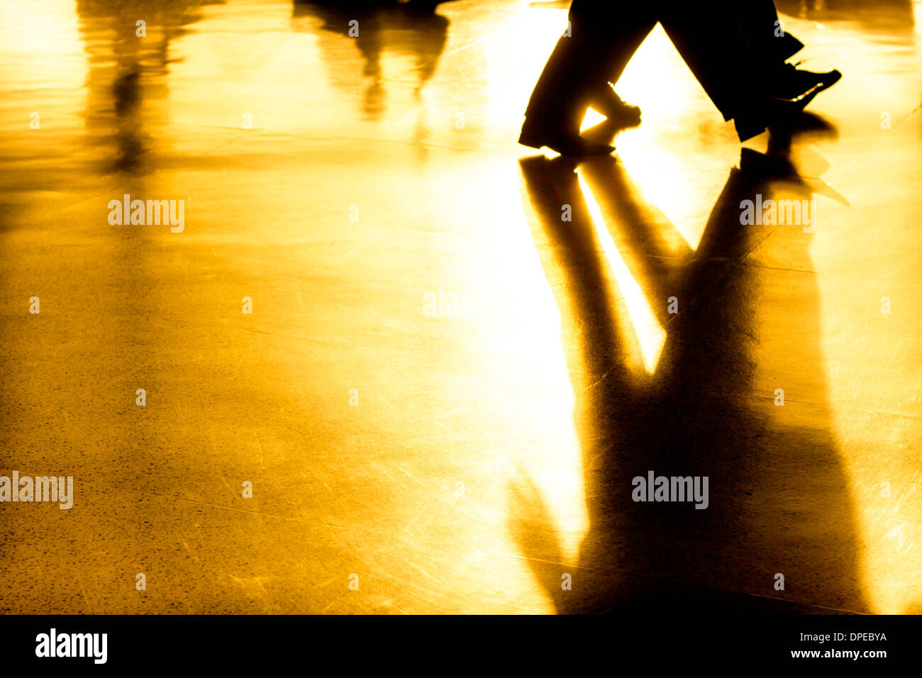 Astratto foto creative di persone sagome di persone a piedi e le loro ombre su sfondo dorato Foto Stock