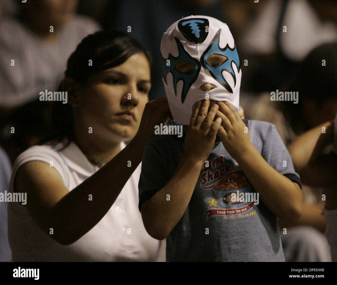 (Pubblicato il 7/24/2005, E-6) Paula Gutierrez, maschera mette sul suo figlio Steven, 5, prima di una serata di Lucha Libre a Sweetwater High School della palestra. Gutierrez è venuto con suo marito Juan e portato entrambi i loro figli Steven e Nicole, 4. Peggy Peattie foto Foto Stock