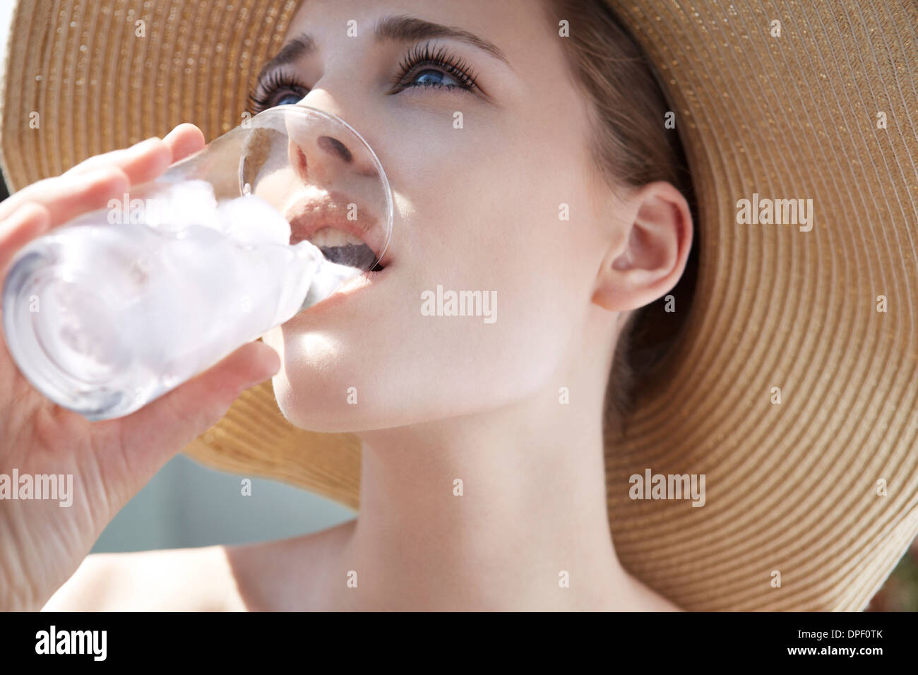 Giovane donna di bere dal bicchiere di ghiaccio Foto Stock