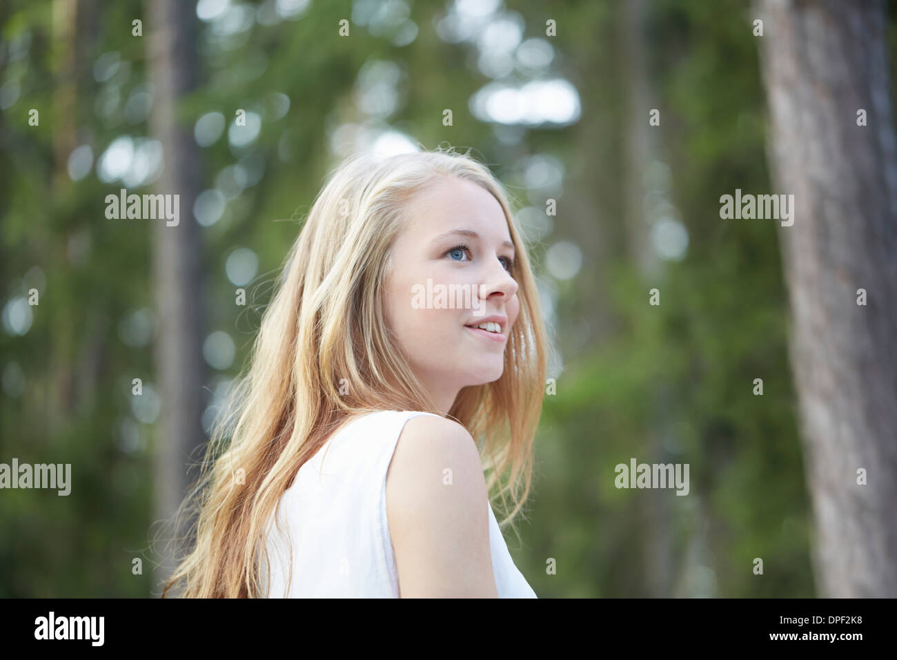 Ritratto di ragazza adolescente con lunghi capelli biondi che guarda lontano Foto Stock