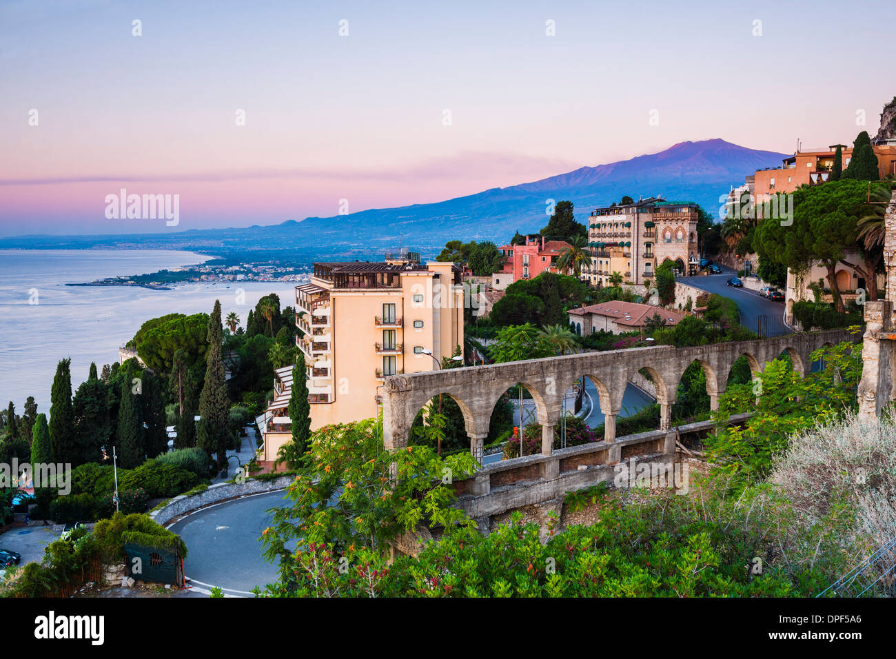 Il monte Etna che salgono sopra Taormina all'alba, la costa orientale della Sicilia, in Italia, Mediterraneo, Europa Foto Stock