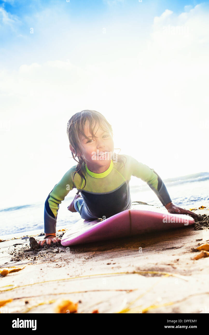 Ragazza giovane praticare surf sulla spiaggia, Encinitas, CALIFORNIA, STATI UNITI D'AMERICA Foto Stock