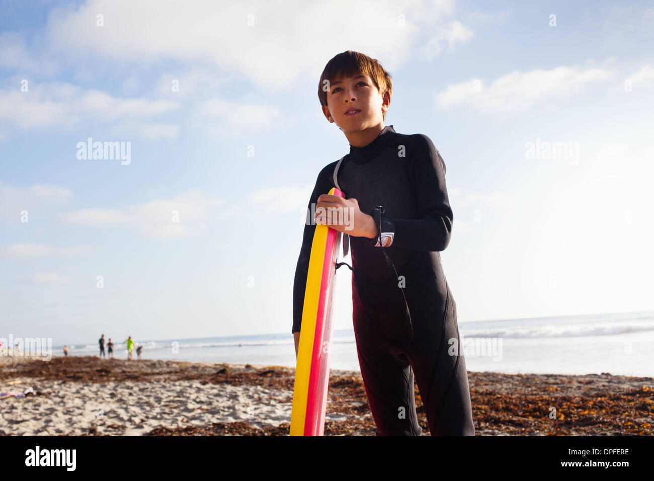 Ragazzo con la tavola da surf sulla spiaggia, Encinitas, CALIFORNIA, STATI UNITI D'AMERICA Foto Stock