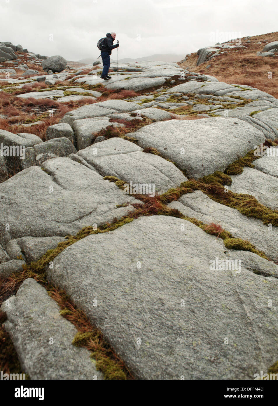 Passeggiate invernali nell'aspro paesaggio delle colline di Galloway. Lastre di granito su Craignairny Foto Stock