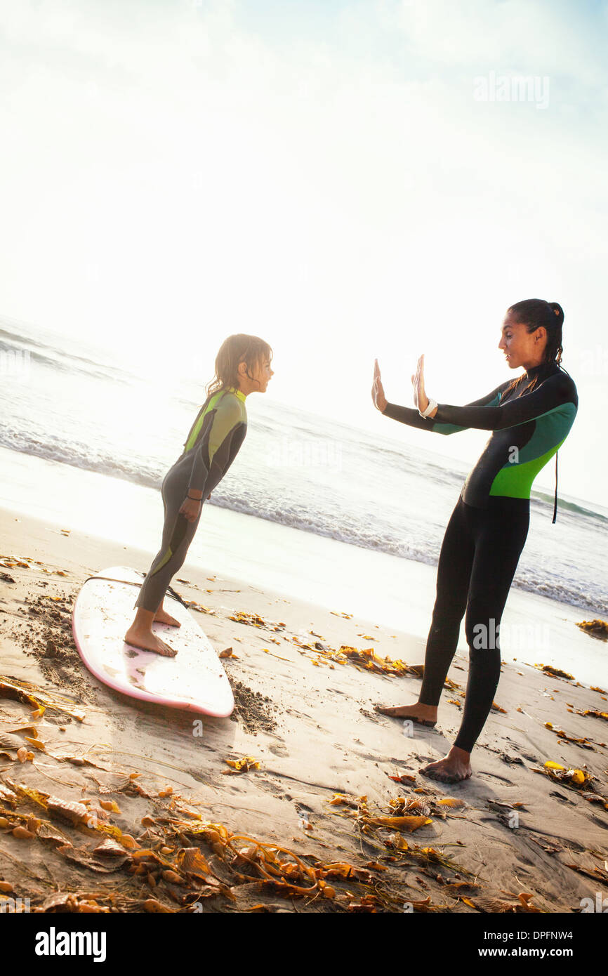 Madre e figlia pratica sulla tavola da surf, Encinitas, CALIFORNIA, STATI UNITI D'AMERICA Foto Stock