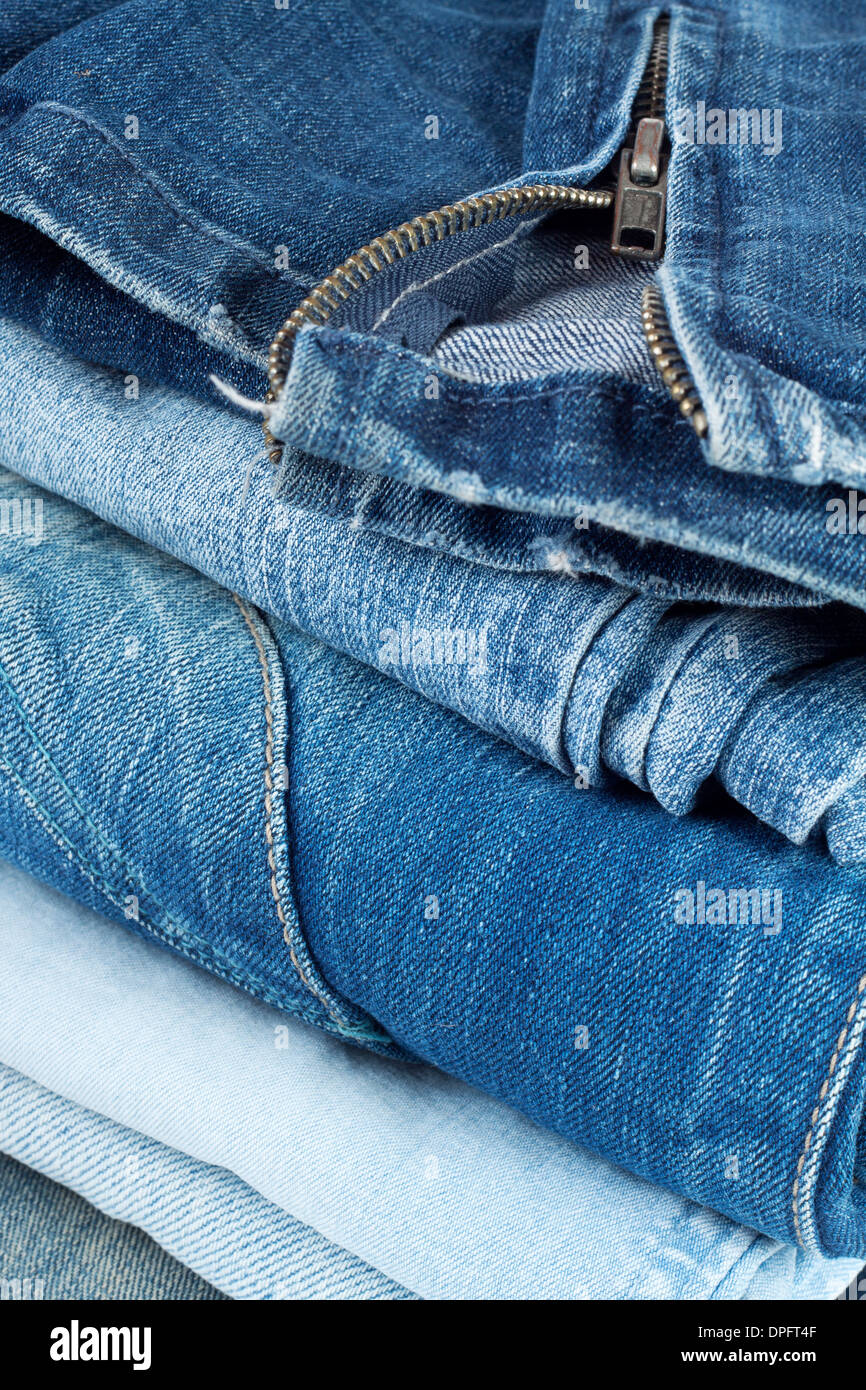 Pila di jeans in diversi colori con un serpente sulla parte superiore Foto  stock - Alamy