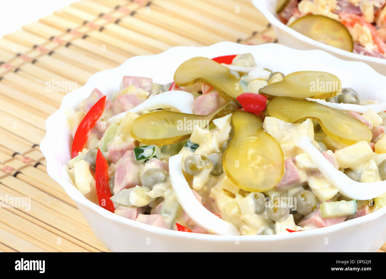 Inverno insalata russa in un piatto bianco su un tovagliolo di bambù sfondo Foto Stock