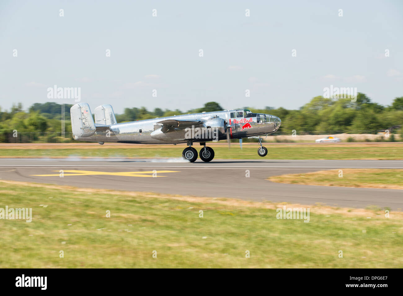 Con una nuvola di fumo dai pneumatici, l'argento Red Bull B-25J Mitchell Guerra Mondiale 2 tocchi bombardiere giù al 2013 RIAT Foto Stock