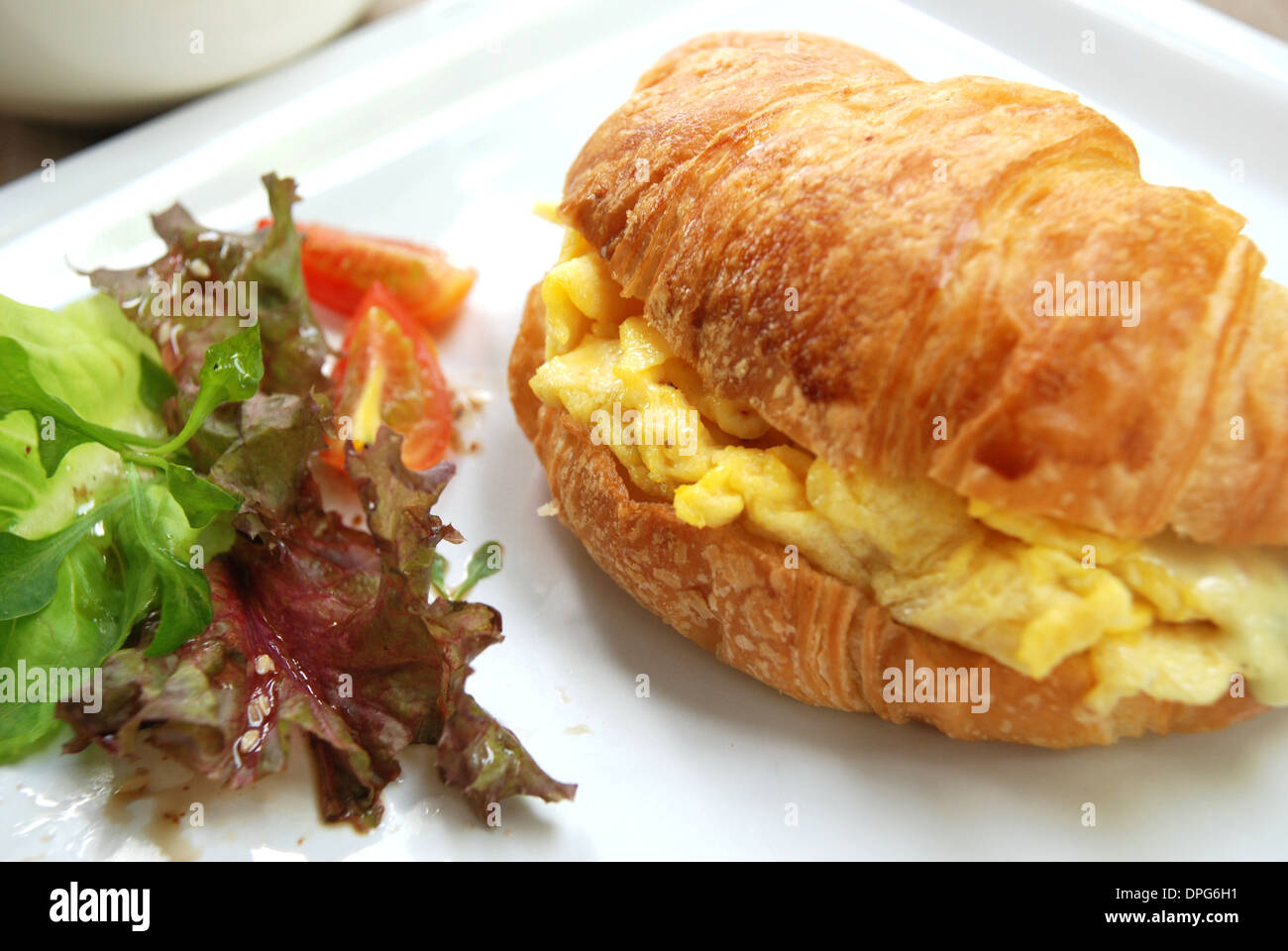 Uova strapazzate sandwich croissant buon piatto per la colazione Foto Stock