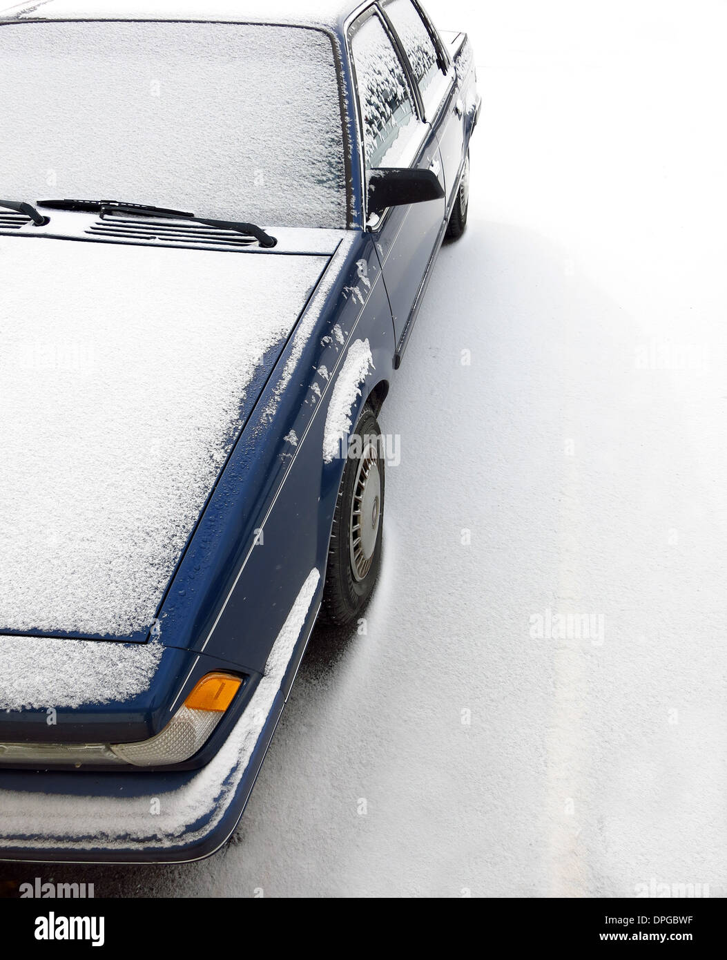 Macchina parcheggiata su una strada coperta di neve durante l'inverno Foto Stock