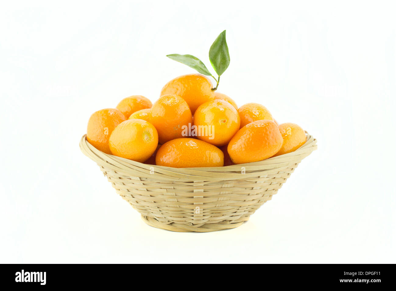 Dolce Piccola frutta di arancia con foglie in piatto di paglia. Foto Stock