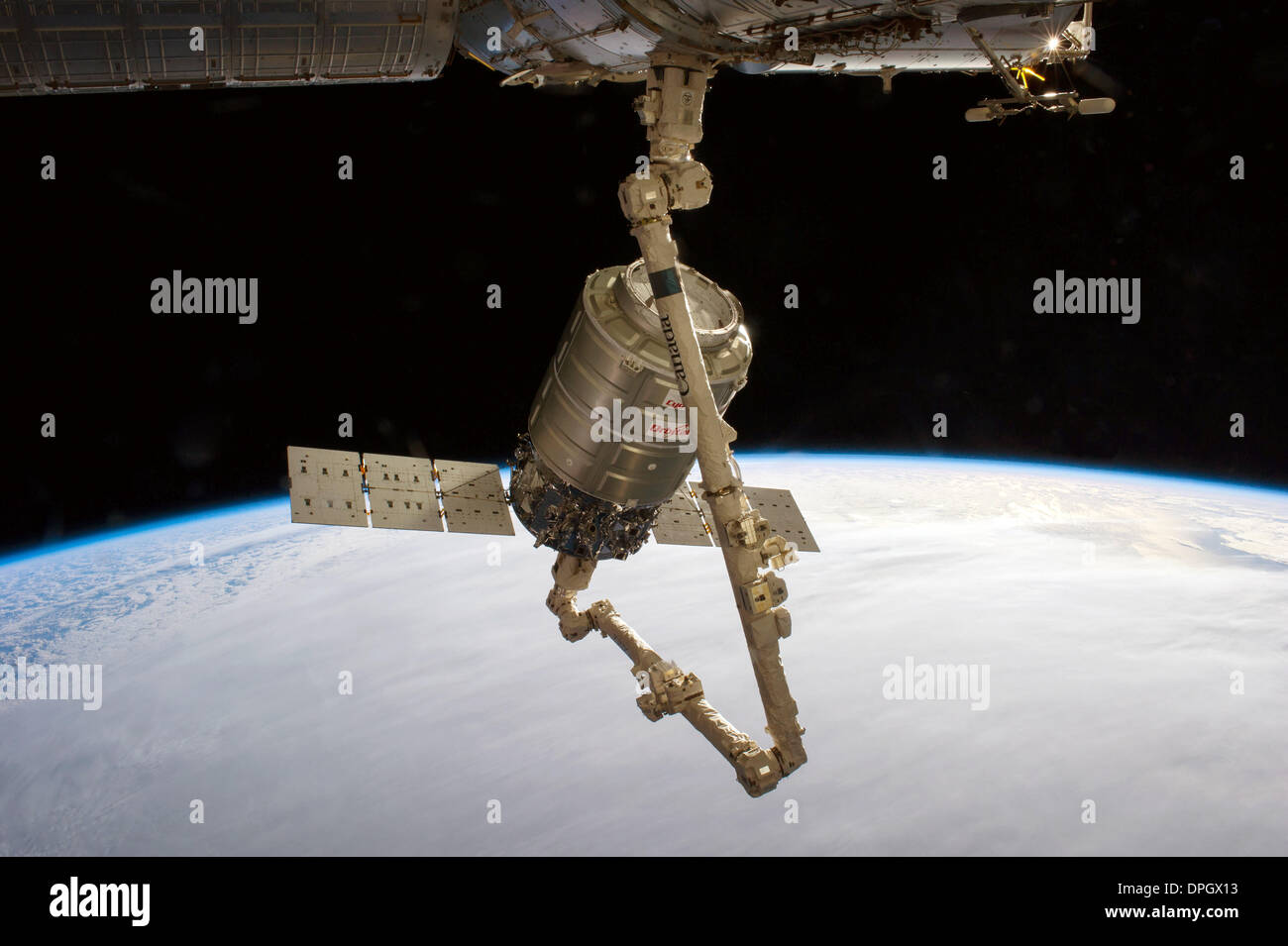 Il Canadarm 2 collega la Orbital Sciences Corp Cygnus commerciale cargo navicella spaziale alla Stazione Spaziale Internazionale il 12 gennaio 2014 in orbita intorno alla terra. Questa è la prima volta che il Cygnus unmanned commerciale nave cargo ha realizzato una consegna alla stazione per la NASA. Credito: Planetpix/Alamy Live News Foto Stock