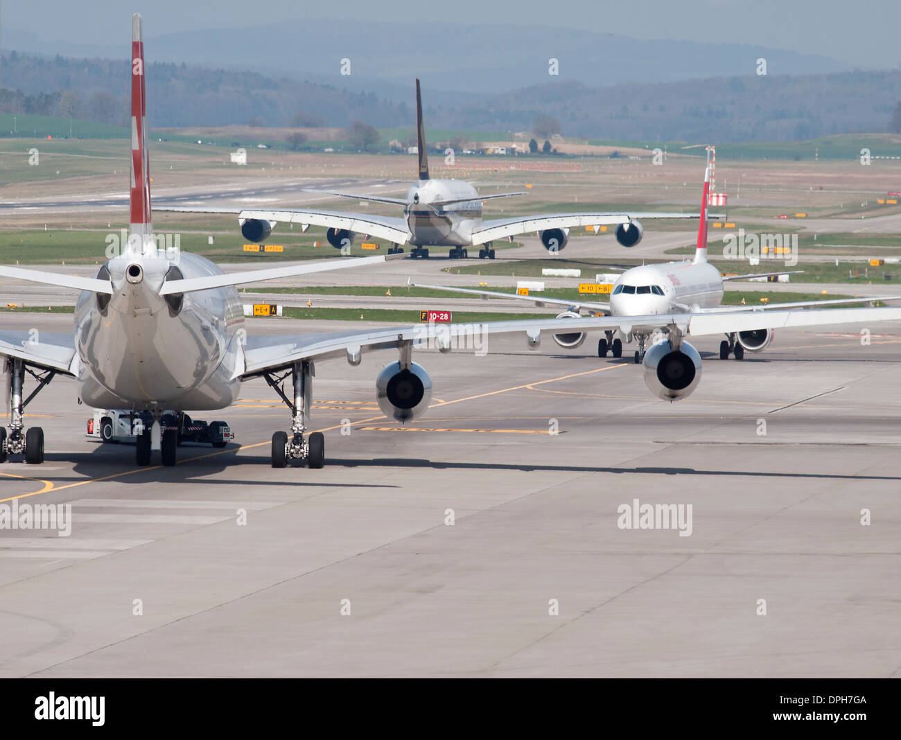 Tre velivoli passeggeri in condizioni di traffico intenso sulla pista di rullaggio dell'aeroporto internazionale di Zurigo. I tipi di aerei sulla foto includono aria Foto Stock