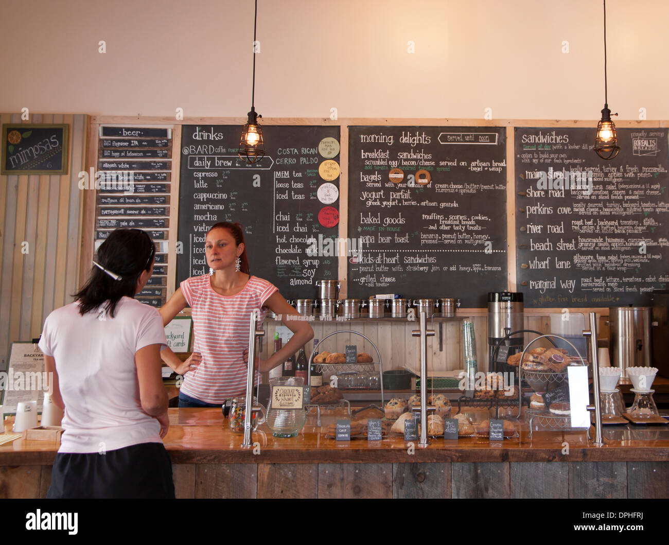 Coffeehouse sandwich e il personale del negozio lavoratore a parlare con il cliente. Foto Stock