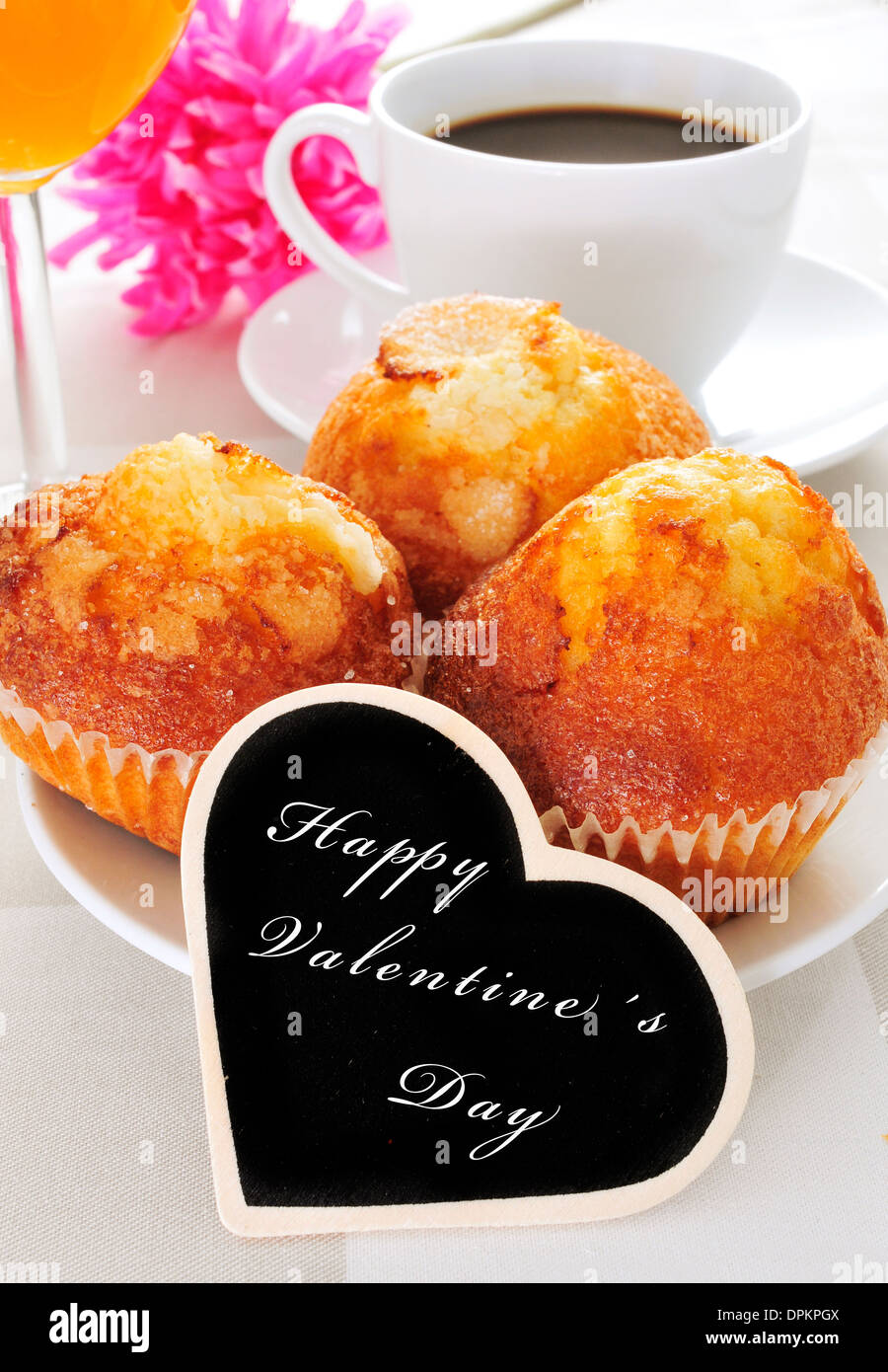 Una prima colazione continentale con muffin, caffè e succo di frutta e la frase felice il giorno di san valentino scritto in una a forma di cuore blackboar Foto Stock