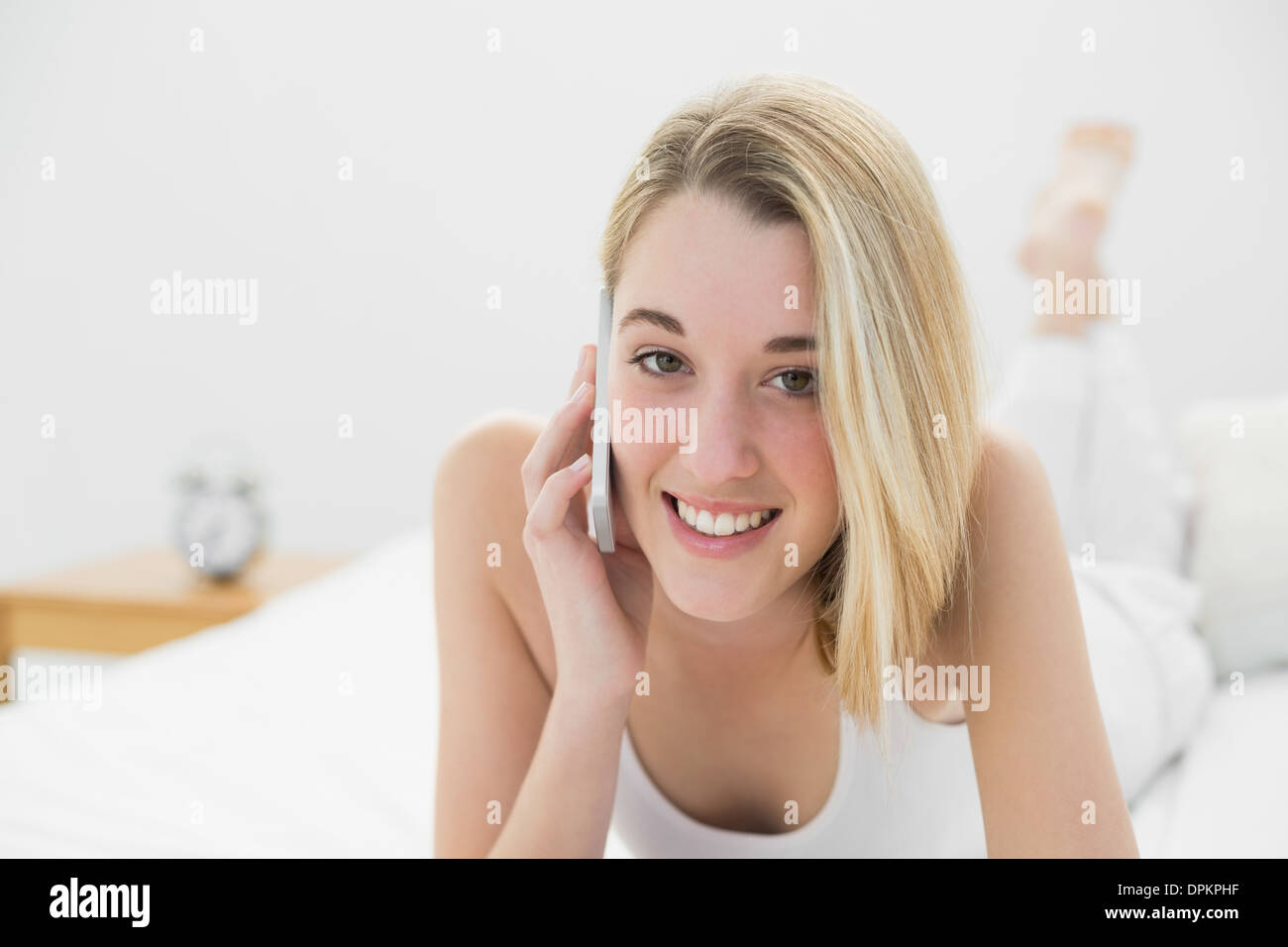 Gleeful giovane donna sorridente alla videocamera mentre si telefona con il suo smartphone Foto Stock