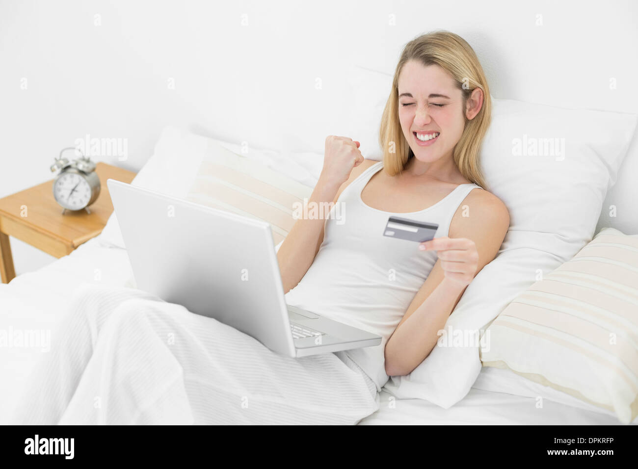 Il successo di una felice donna home shopping con il notebook Foto Stock