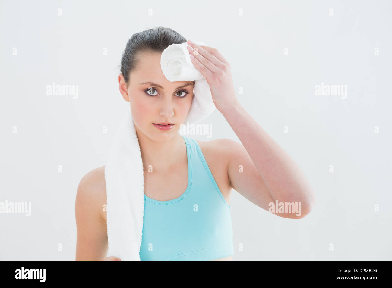 Close up donna tergi sudore con asciugamano contro la parete Foto Stock