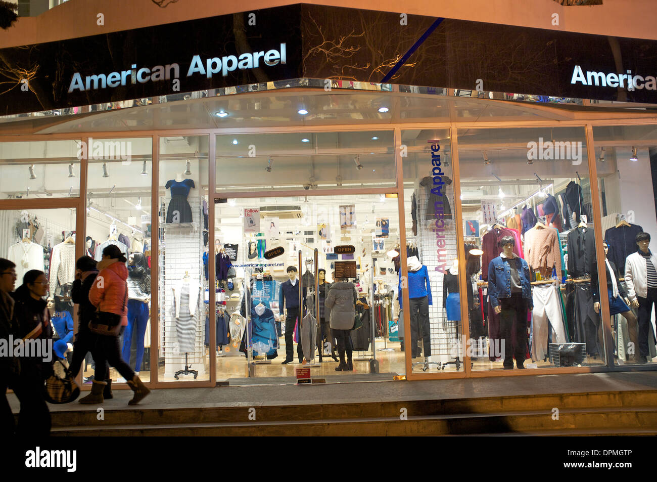 La gente a piedi passato un American Apparel Store di Sanlitun a Pechino, Cina. 11-Gen-2014 Foto Stock