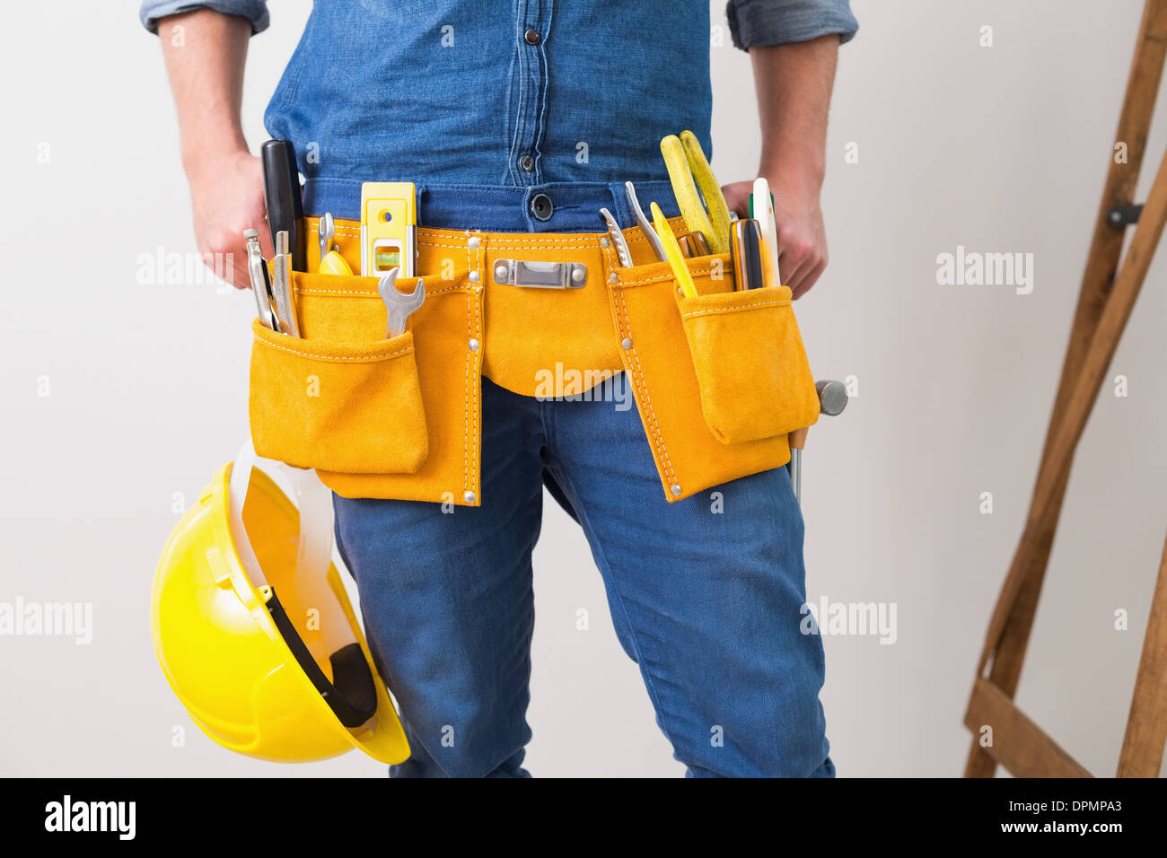 La sezione centrale del tuttofare con toolbelt ed elmetto Foto Stock