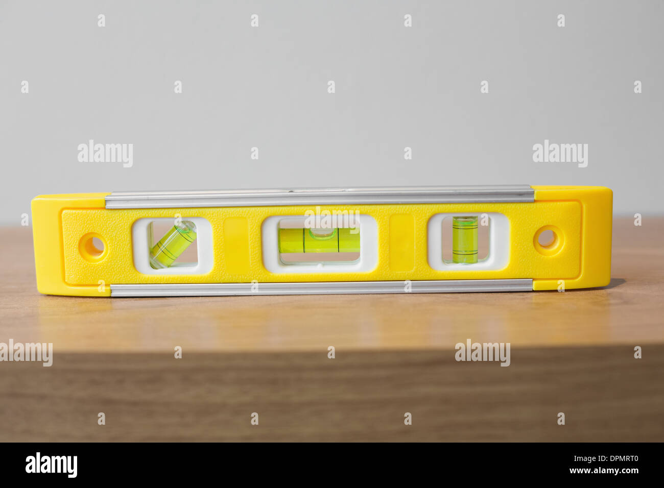 La livella sulla superficie di legno contro il muro Foto Stock