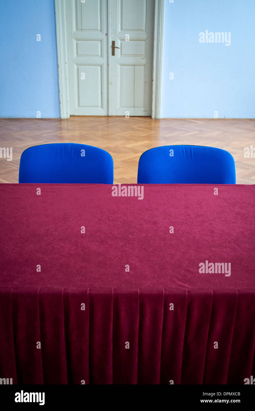 Sedie blu e tavolo con pesanti colore borgogna tovaglia in un 50s stile comunista hall Foto Stock