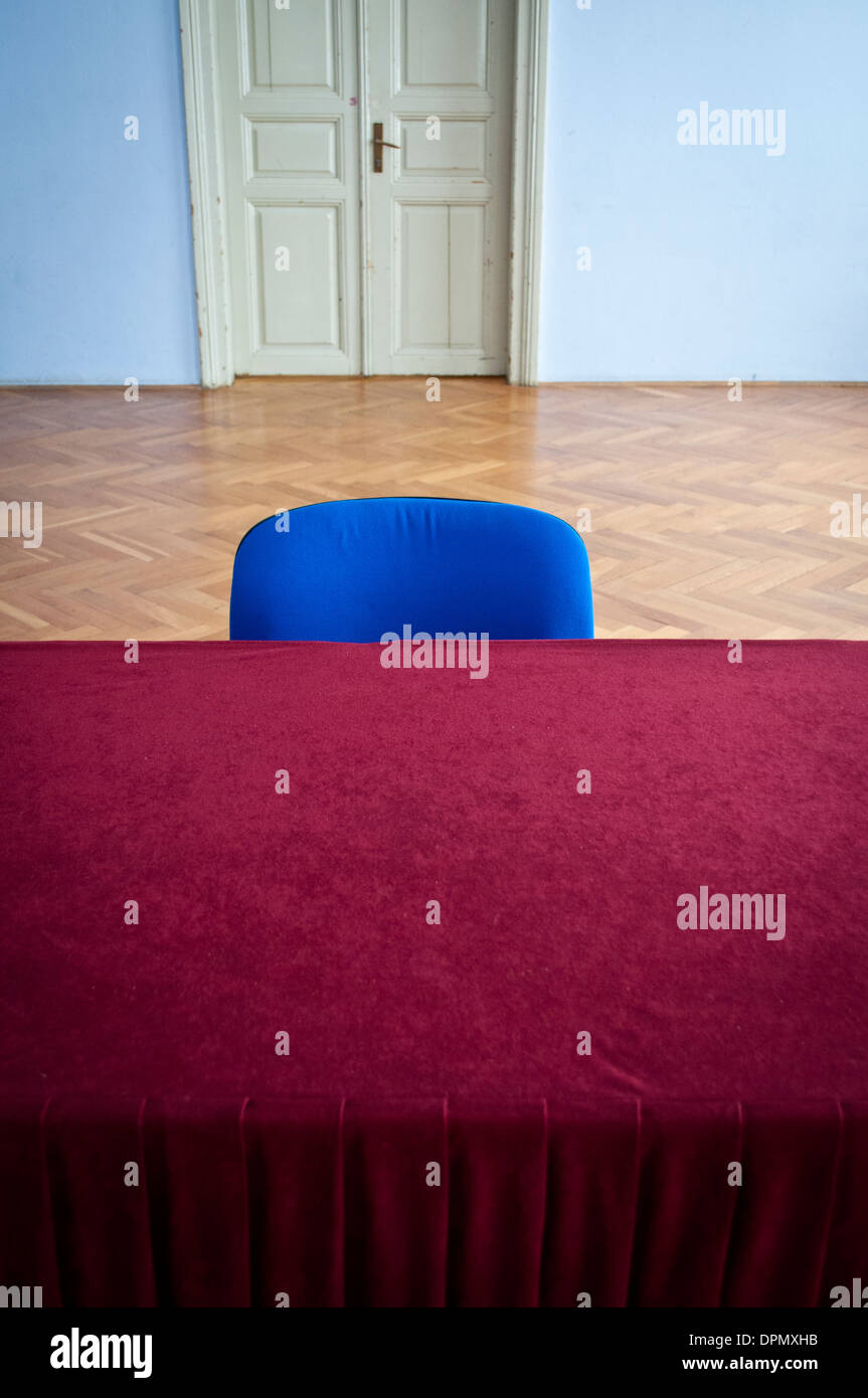 Blue sedia e tavolo con pesanti colore borgogna tovaglia in un 50s stile comunista hall Foto Stock