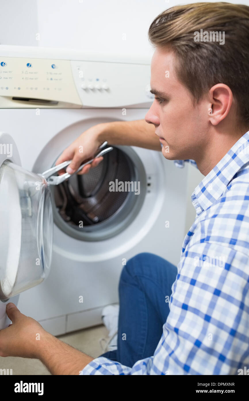 Il tecnico di riparazione di una macchina di lavaggio Foto Stock