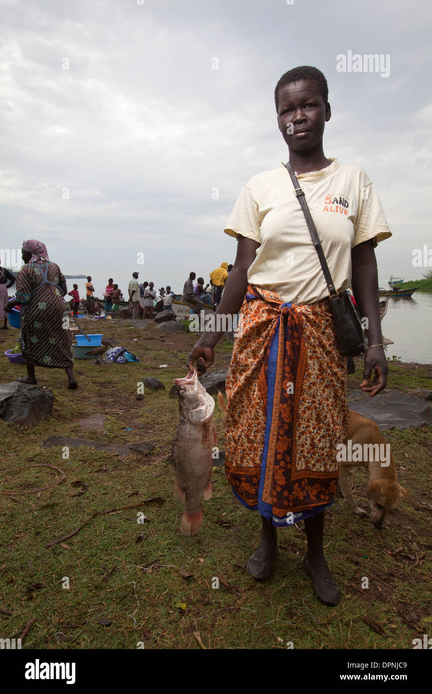 Donna che mantiene il pesce persico del Nilo (ritardatari niloticus) Kisumu, il lago Victoria, Kenya Foto Stock