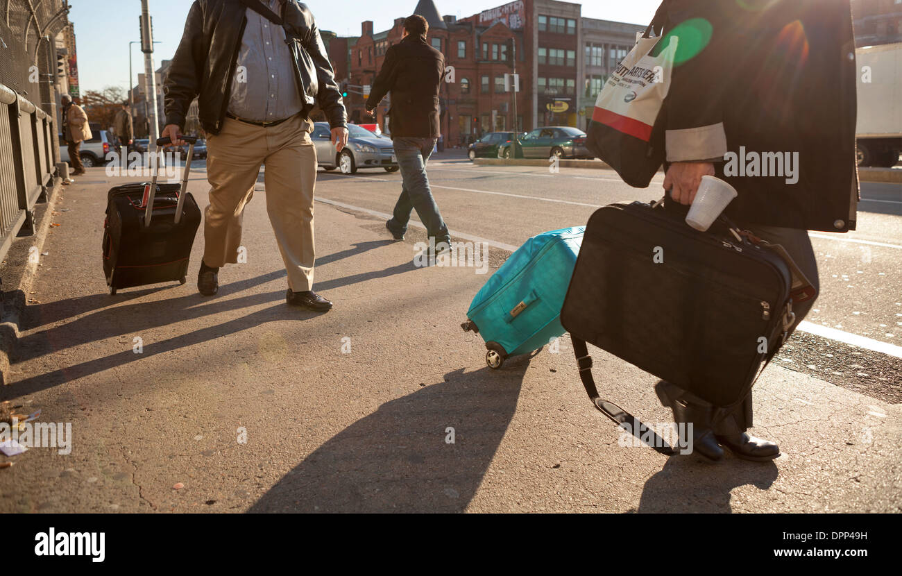 La gente a tirare le loro valigie sul marciapiede in Boston come loro capo alla stazione della metropolitana. Foto Stock