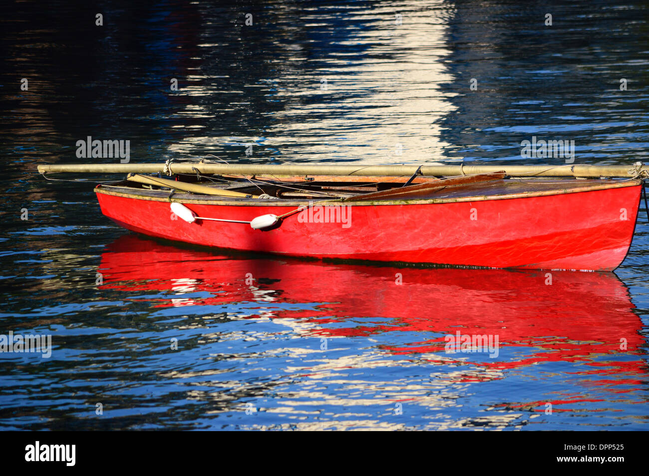 Rosso barca a vela, montante giù e ormeggiata in porto Foto Stock