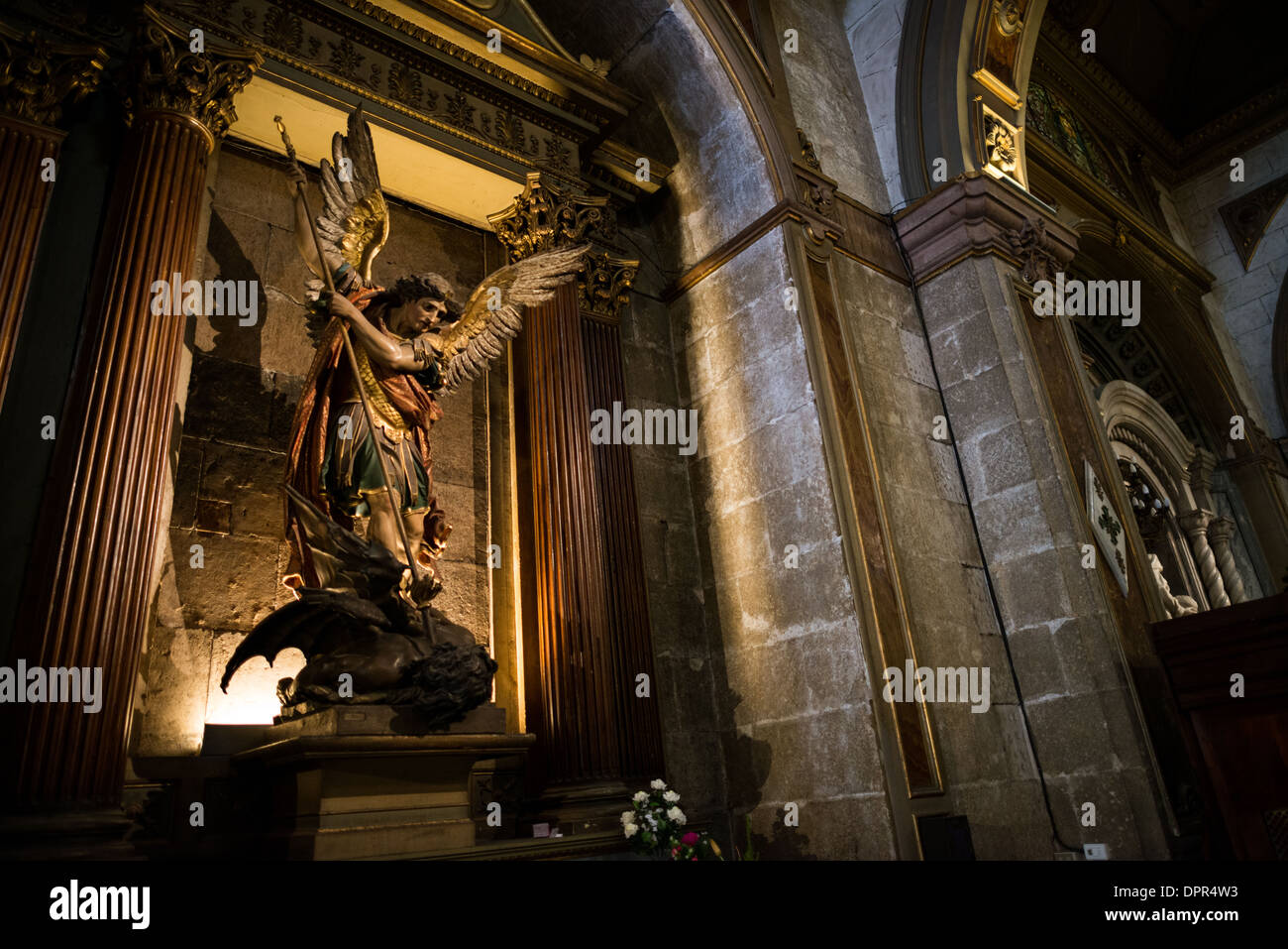 Statua di San Michele Cattedrale metropolitana di Santiago del Cile // SANTIAGO del Cile — Una statua raffigurante San Michele Arcangelo che uccide il drago si trova all'interno della Cattedrale metropolitana, un'importante chiesa cattolica nella capitale del Cile. Il pezzo scultoreo rappresenta la tradizionale iconografia cattolica che simboleggia il trionfo del bene sul male, con San Michele che sconfigge Satana sotto forma di drago. La Cattedrale metropolitana, situata sul lato occidentale di Plaza de Armas, funge da sede dell'Arcidiocesi di Santiago e ospita numerose opere d'arte religiose risalenti a vari perio Foto Stock