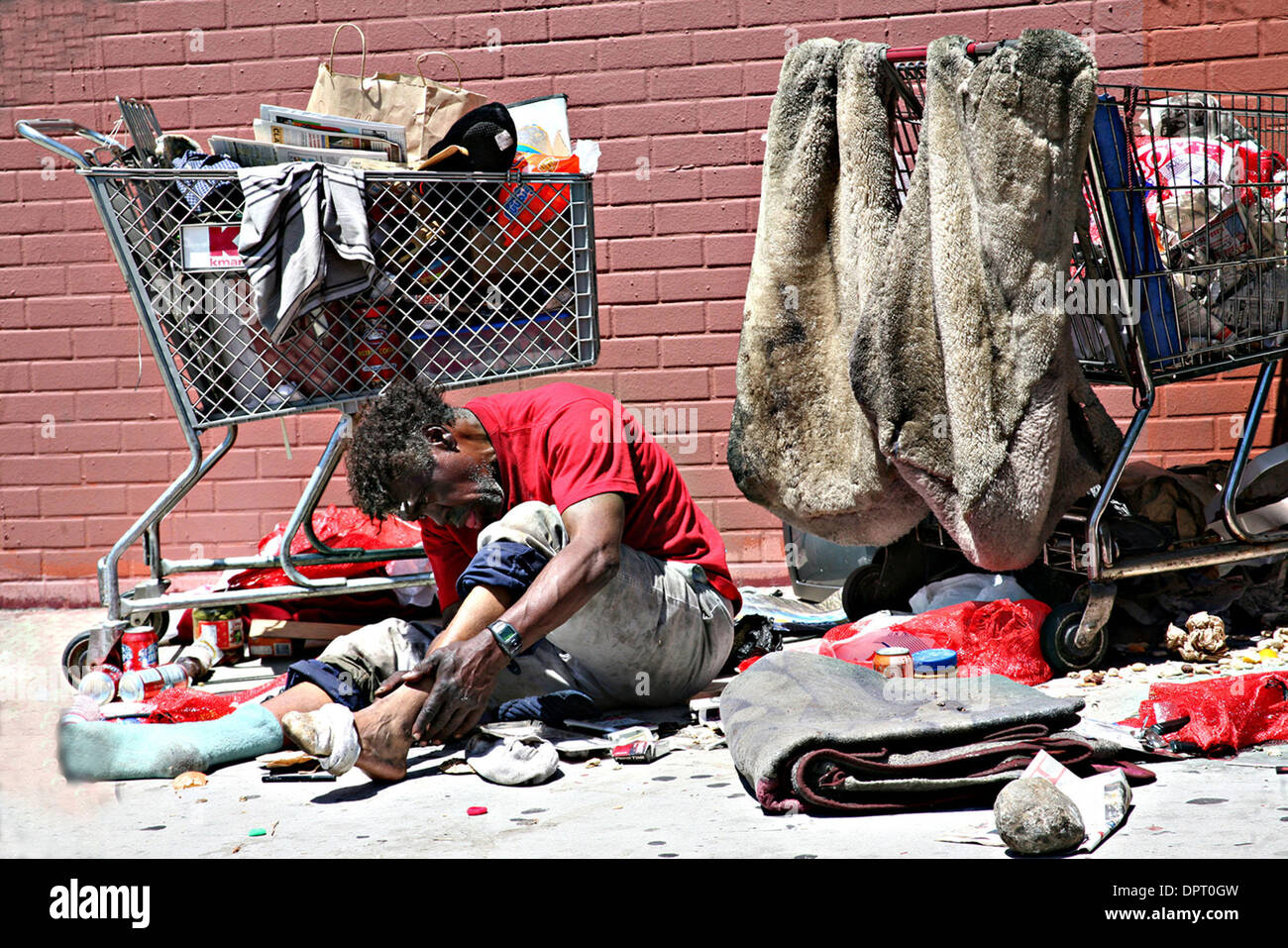 Maggio 06, 2009 - Los Angeles, California, Stati Uniti - Senzatetto pulisce i piedi vicino il suo carrello. Secondo l'Istituto per lo studio del fenomeno dei senzatetto e della povertà al centro Weingart, una stima di 254,000 uomini, donne e bambini l'esperienza dei senzatetto nella Contea di Los Angeles durante una parte dell'anno e circa 82.000 persone sono senza tetto in un qualsiasi dato di notte. I giovani non accompagnati Foto Stock