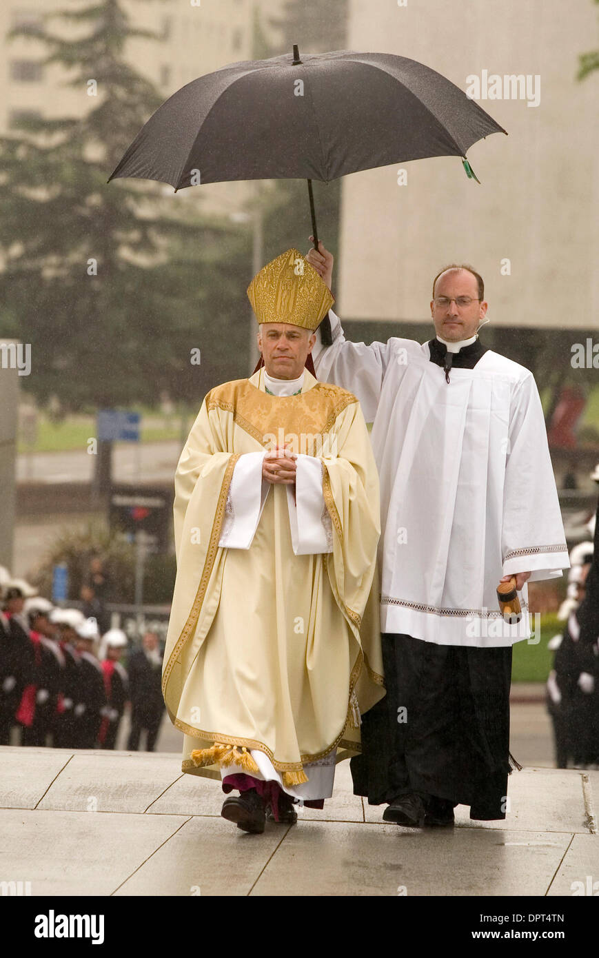 Una chiesa non identificato funzionario tiene un ombrello sopra il nuovo Vescovo di Oakland, California Diocesi cattolica romana, Salvatore Giuseppe Cordileone, sinistra, come egli arriva per cerimonie di installazione presso la Cattedrale di Cristo alla luce, martedì 5 maggio 2009 a Oakland. Cordileone diventa il quarto Vescovo di Oakland. (D. Ross Cameron/personale) Foto Stock