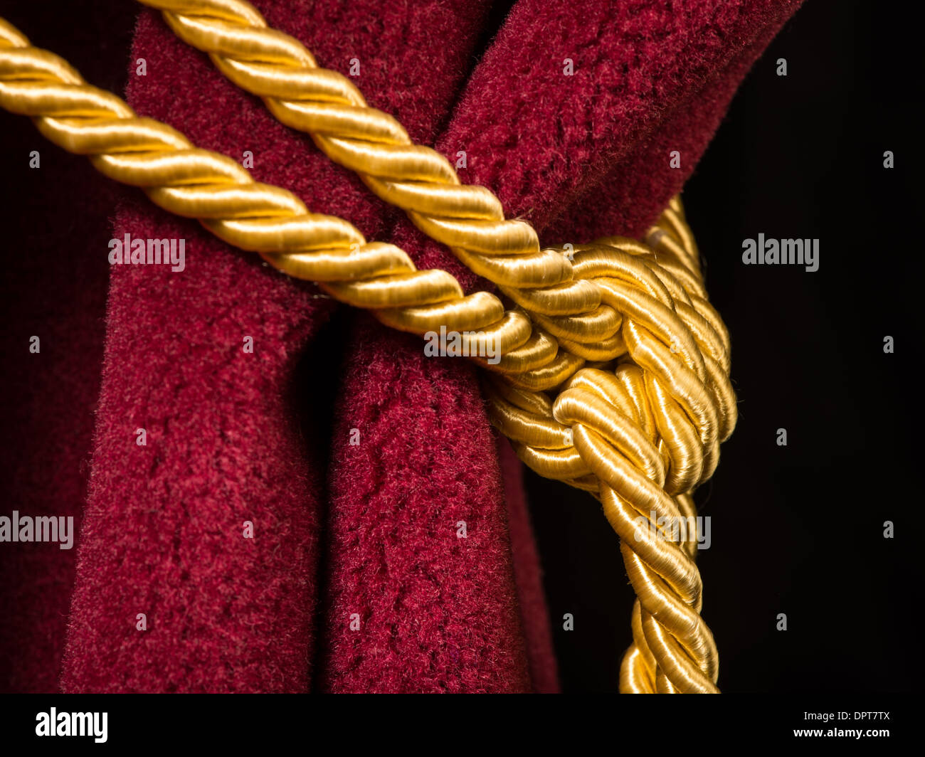 Rosso tenda in velluto con fiocco. Chiudere il nodo sulla corda Foto Stock