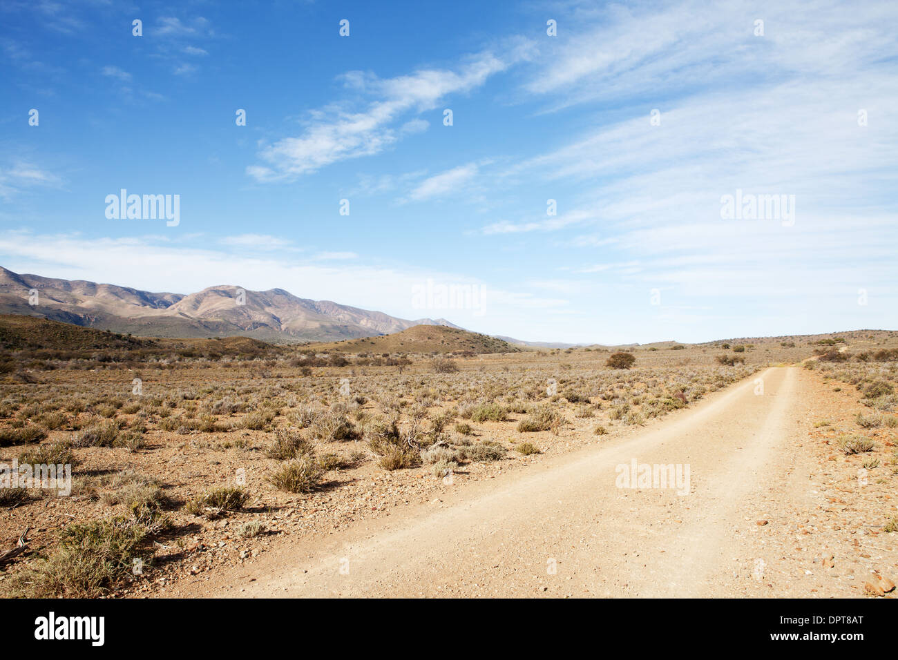 Strada sterrata in secca semi-regione desertica che conduce lontano dal visualizzatore Foto Stock